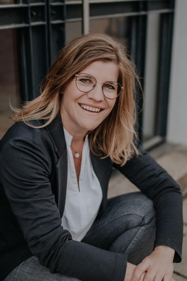 Kerstin sitzt draußen und lächelt